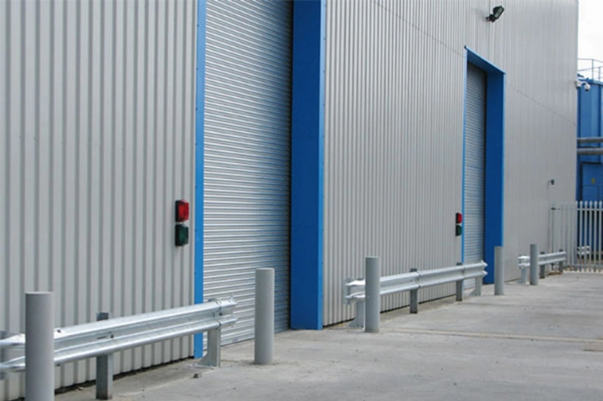 Technicians installing side cladding panels on an industrial façade